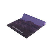 Rolled yoga mat with purple underside and nature scene print.