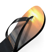 Black flip-flop with sunset on sole against white background.