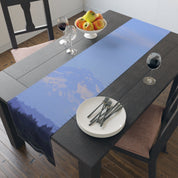 Table runner with mountain landscape, plate, glasses, and fruit bowl.