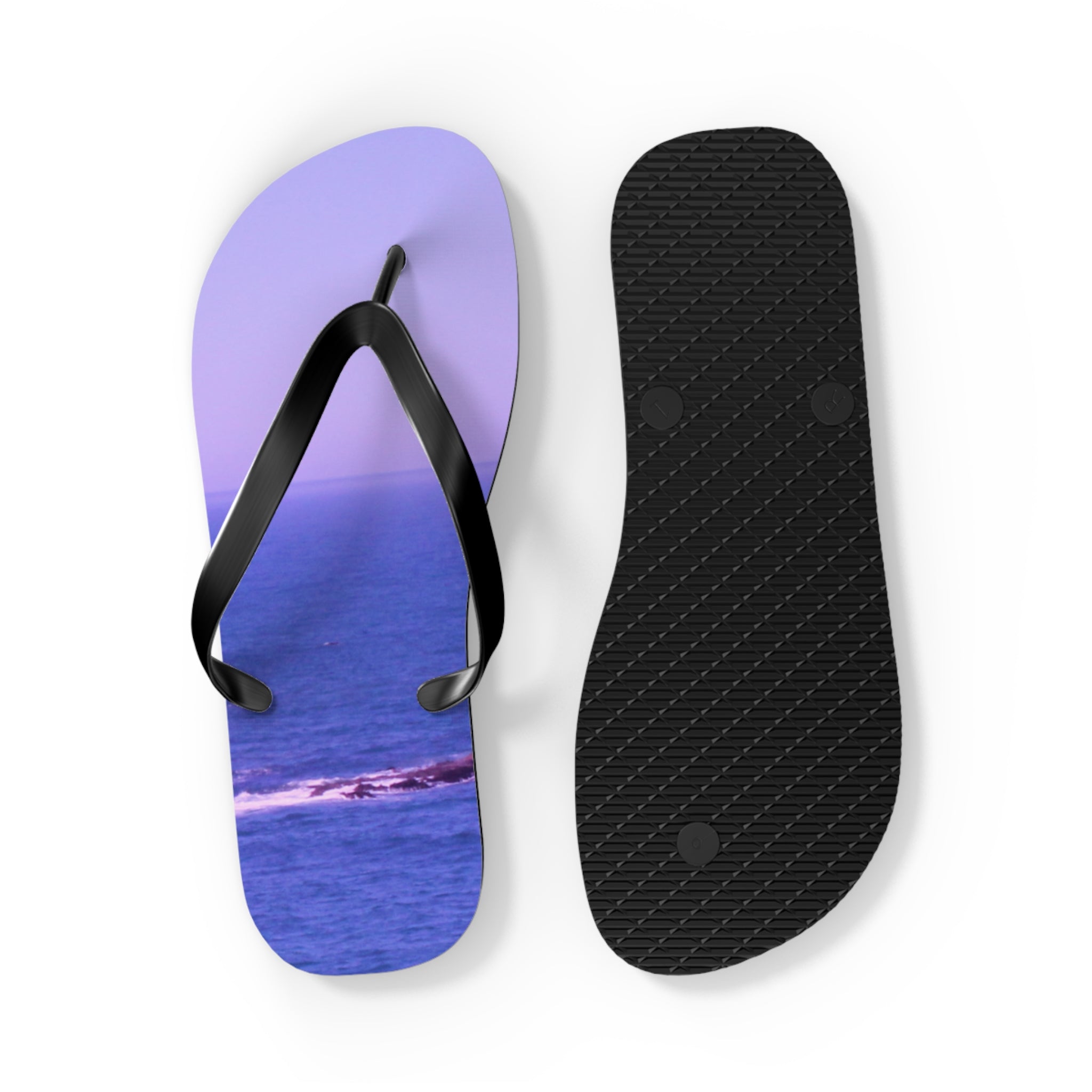 Purple flip-flops with an ocean wave scene, displayed flat.