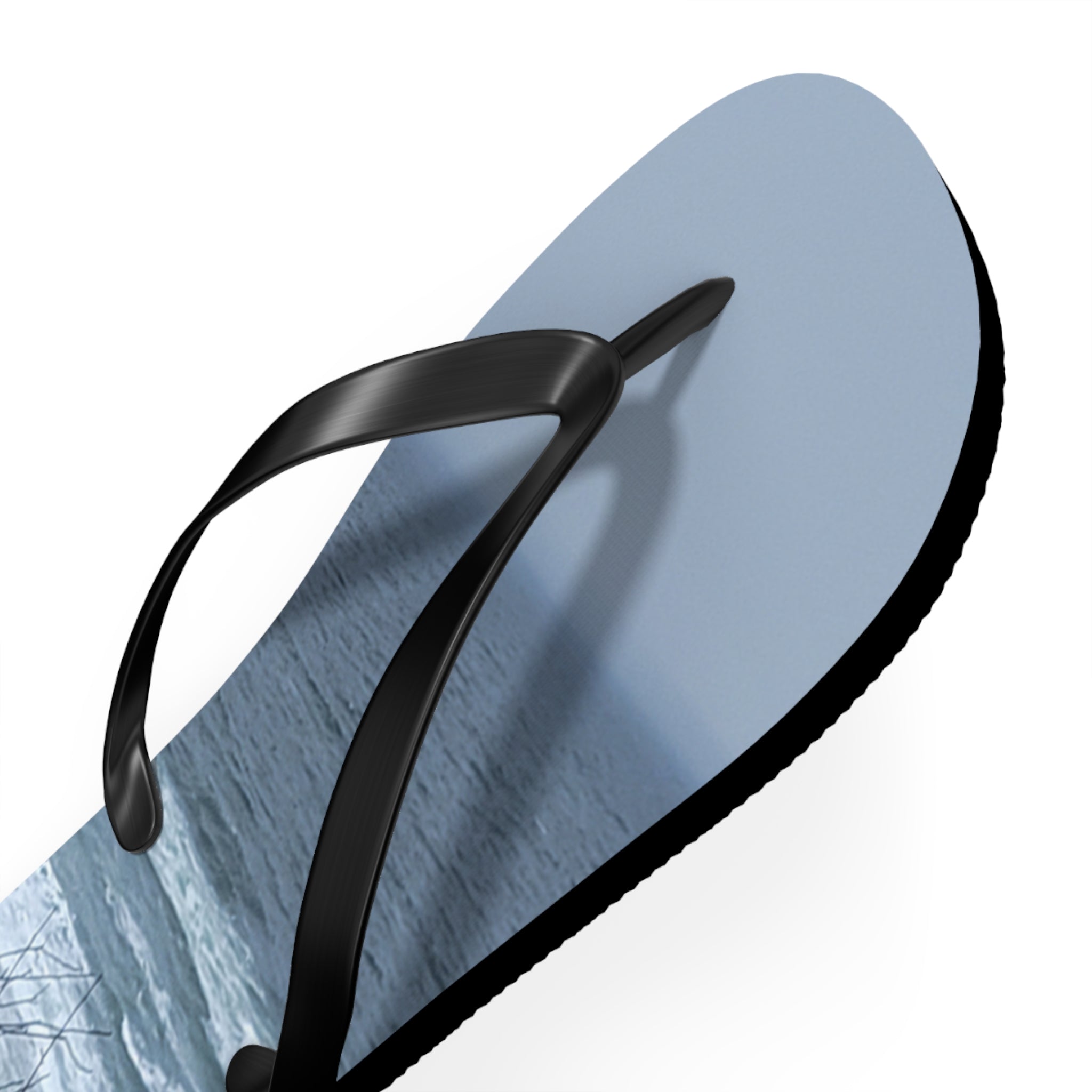 Light blue flip-flop with a seascape design and black straps.