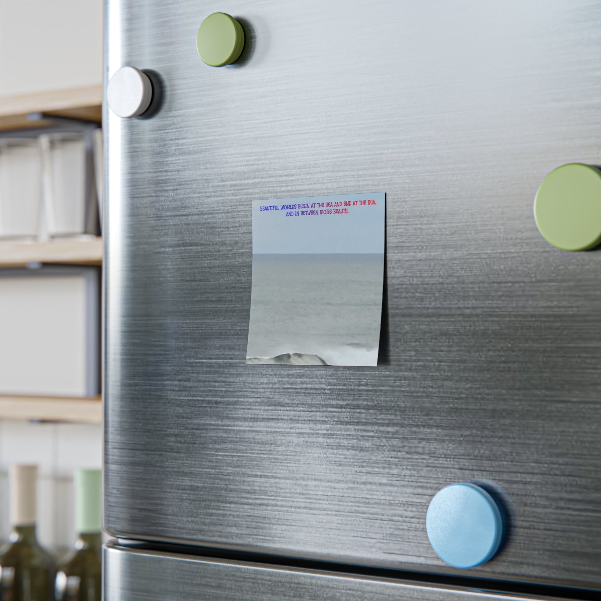 Magnetic note on refrigerator with text about beautiful worlds and the sea.
