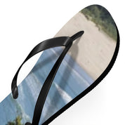 Black flip-flop with a beach scene of waves and sand on the sole.