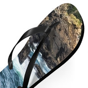 Black flip-flop with a rocky coastline and ocean wave design.