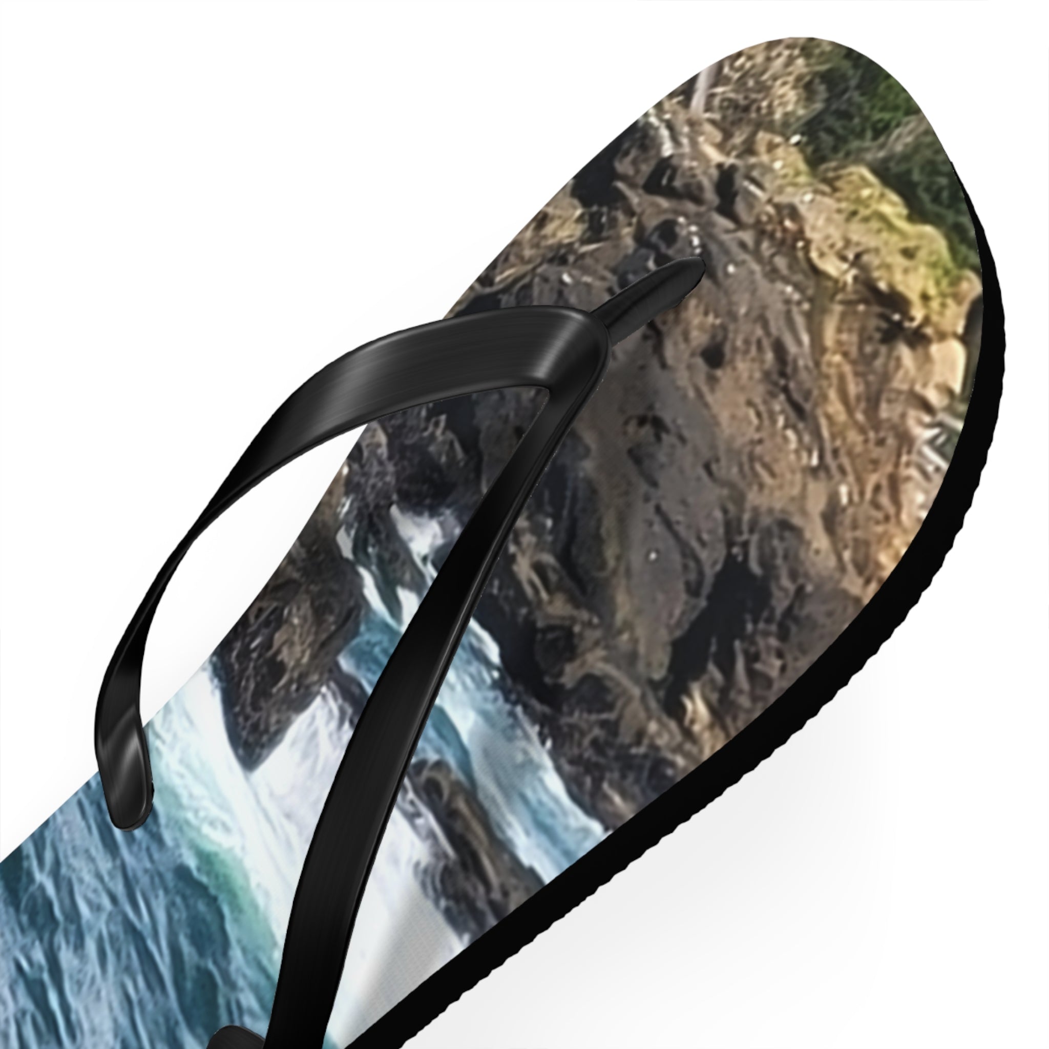 Black flip-flop with a rocky coastline and ocean wave design.