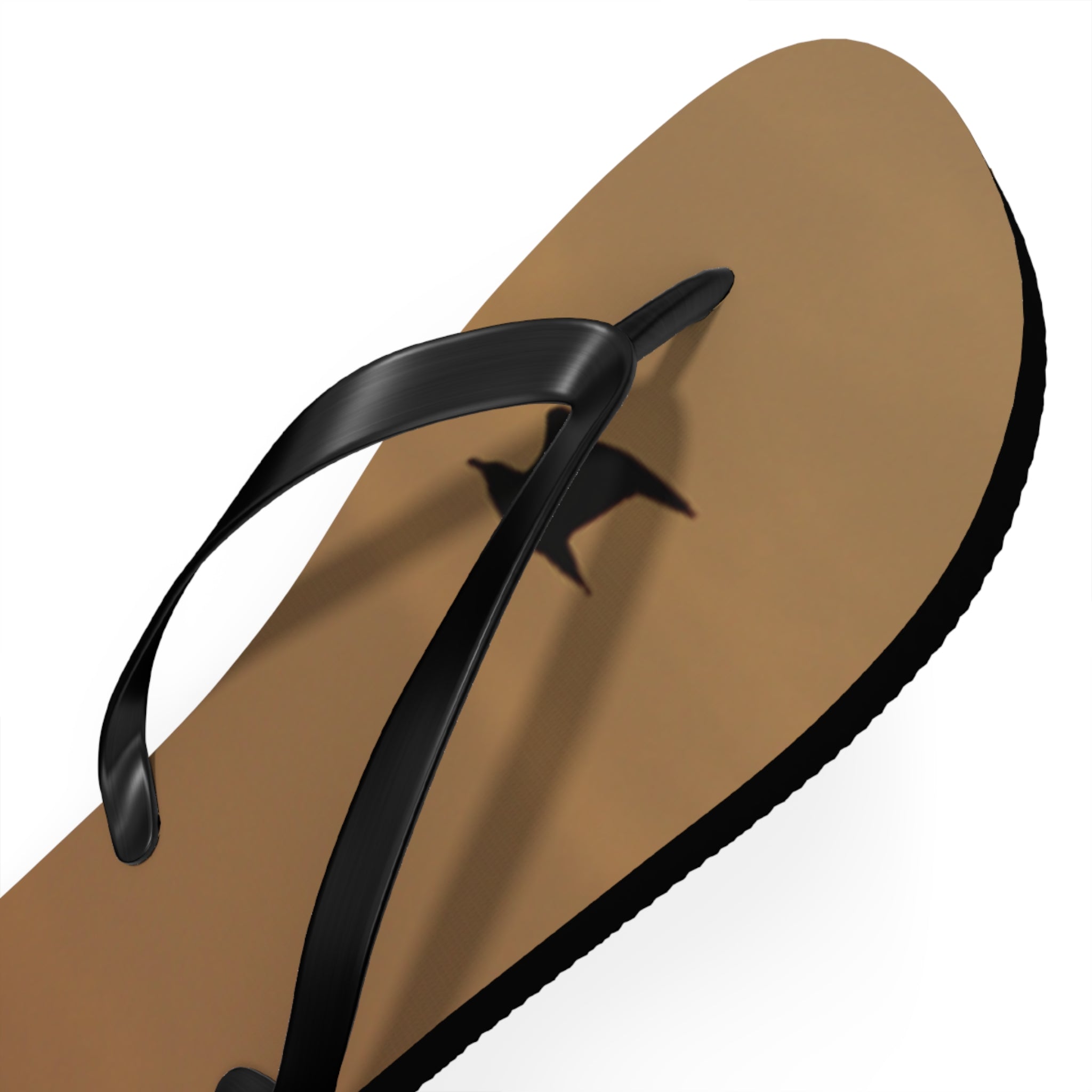 Tan flip-flop with black straps and a black bird silhouette shadow.
