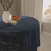 Dark blue marbled tablecloth on a round table with fruit bowl and vase.