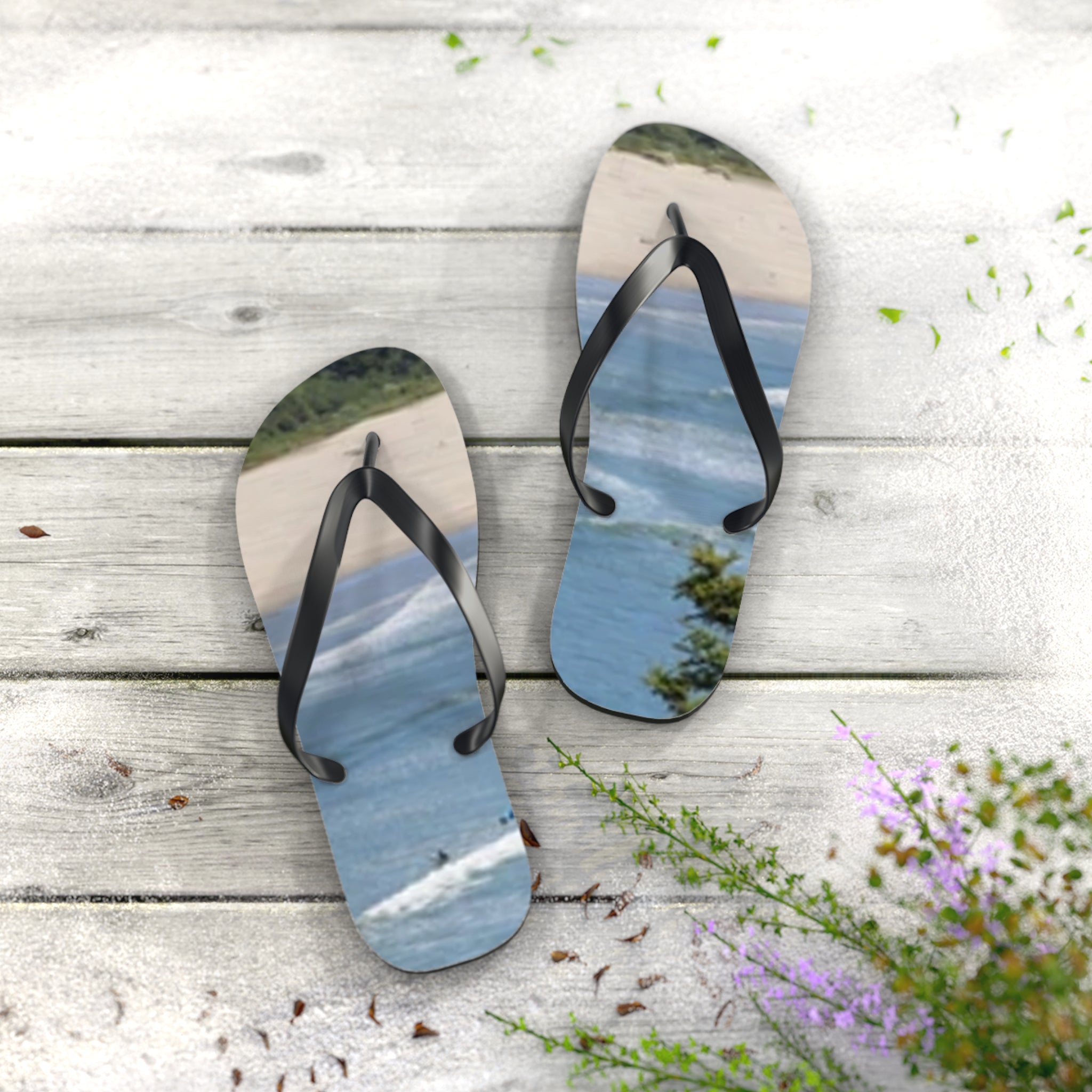 Flip-flops with ocean waves and surfer on a wooden surface.