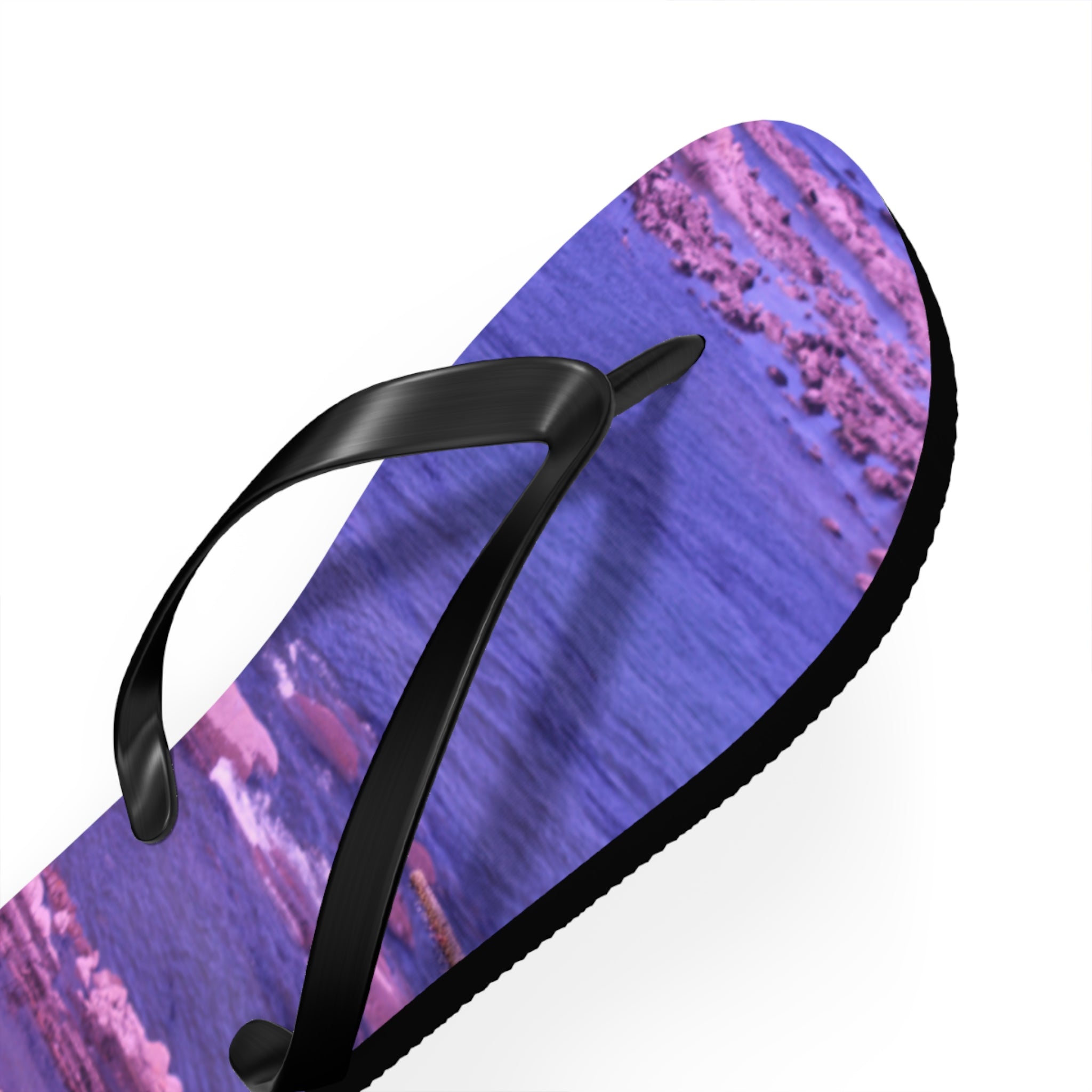 Purple flip-flop with a wave pattern on a white background.
