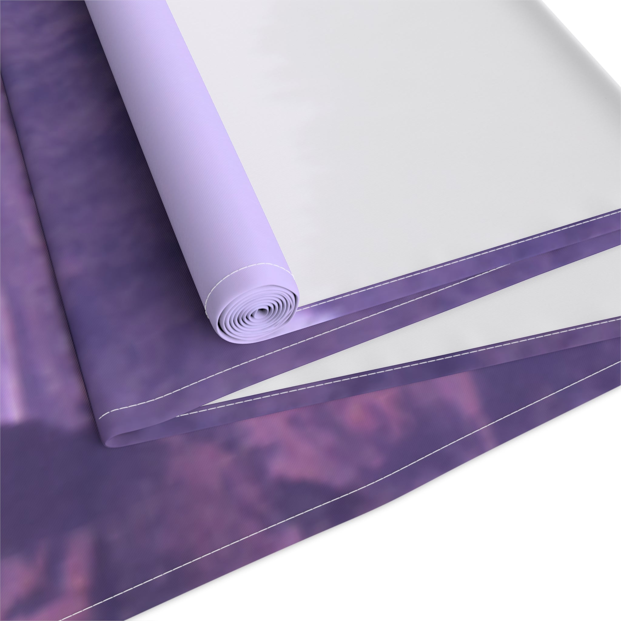 Rolled purple fabric with a white border and blurry purple pattern.