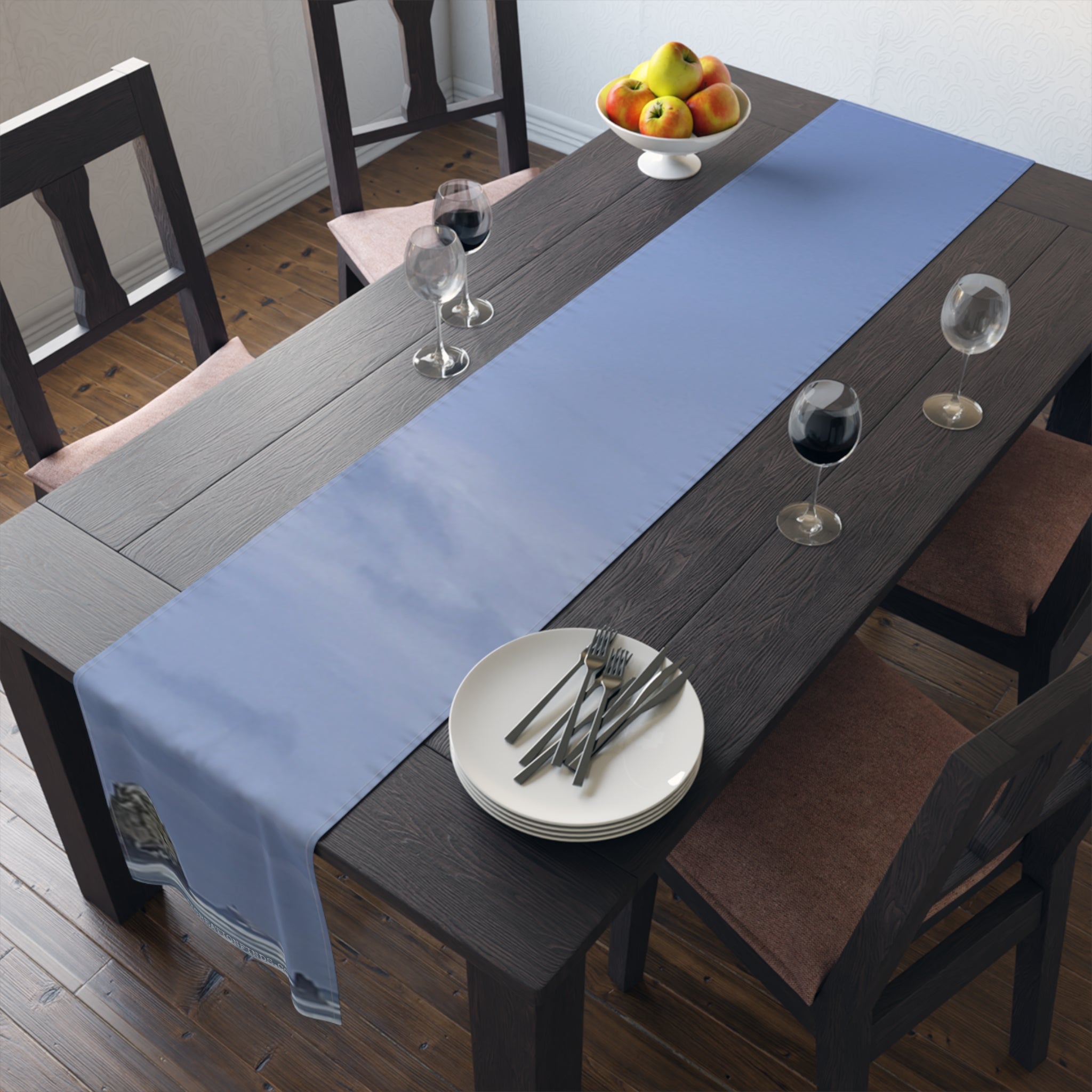 Blue table runner with sky and clouds pattern on dark wood table.