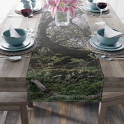 Moss-covered tree branches and greenery on a table runner.