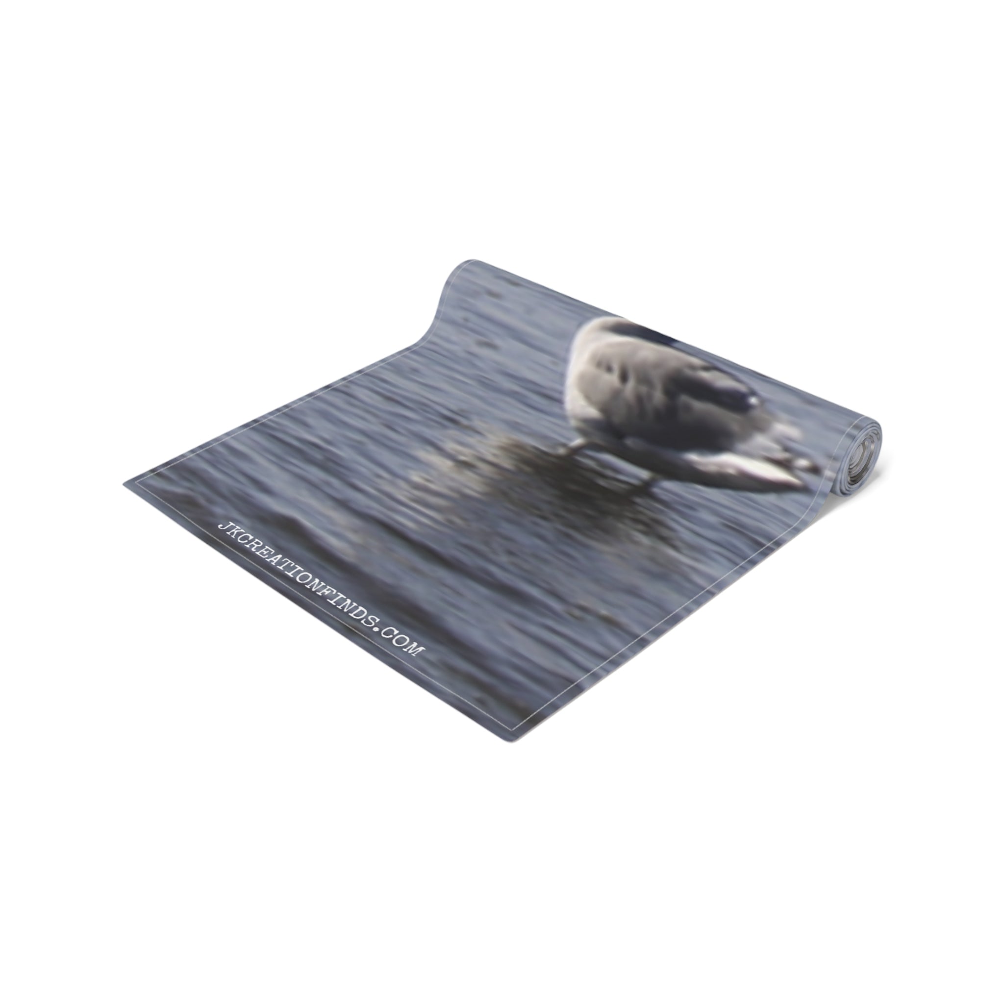 Rolled yoga mat with a duck on water pattern and website address.