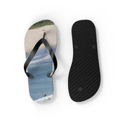 Black flip-flop with a beach and ocean scene on the sole.