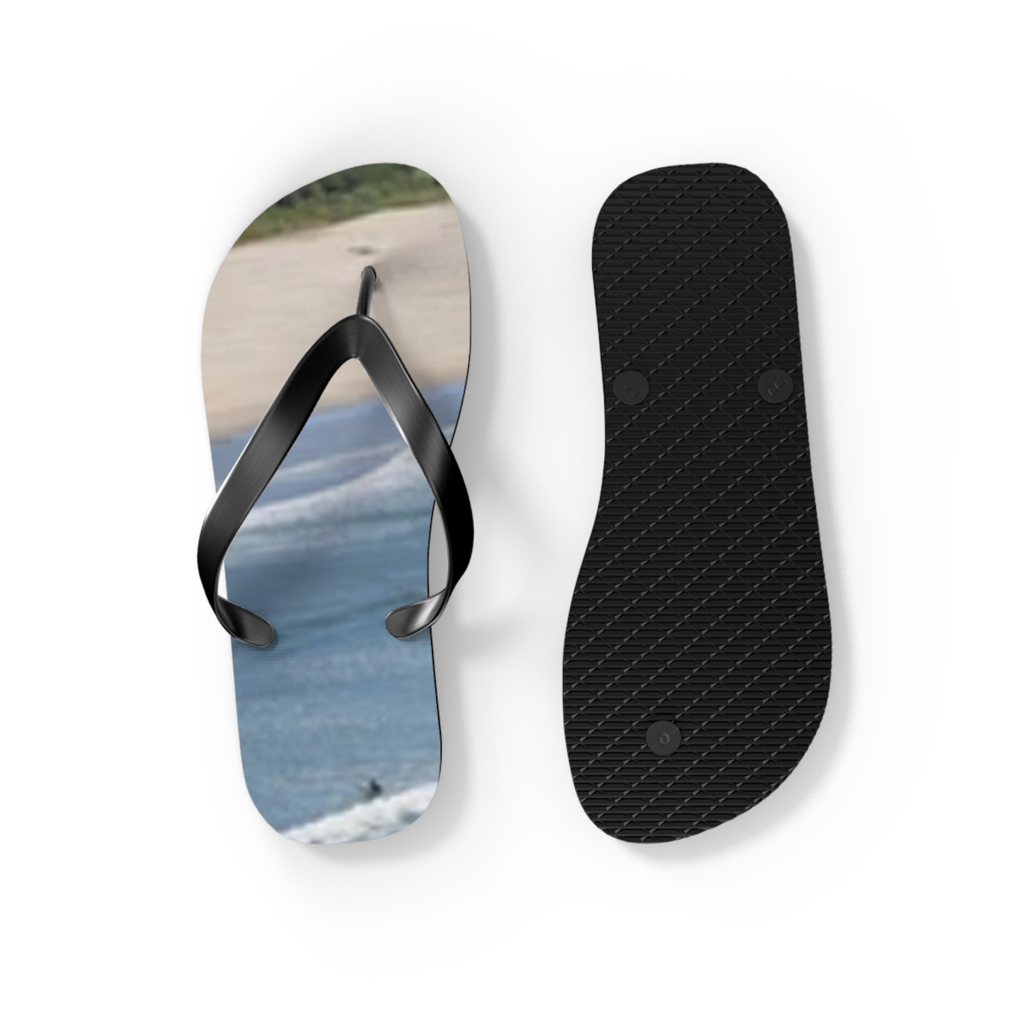 Black flip-flop with a beach and ocean scene on the sole.
