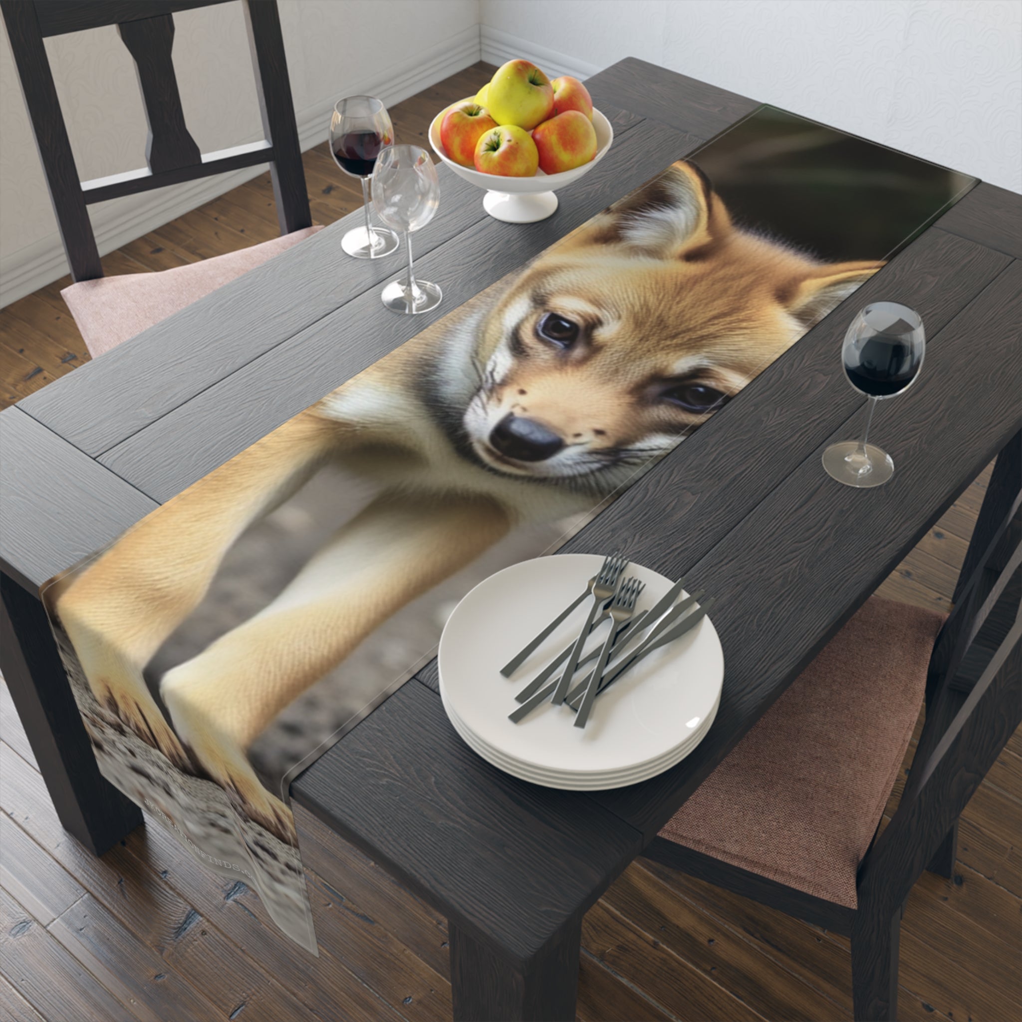 Young Shiba Inu puppy on a table runner with plates and cutlery.