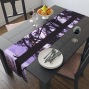 Table runner with purple tree silhouette and white plates with forks.