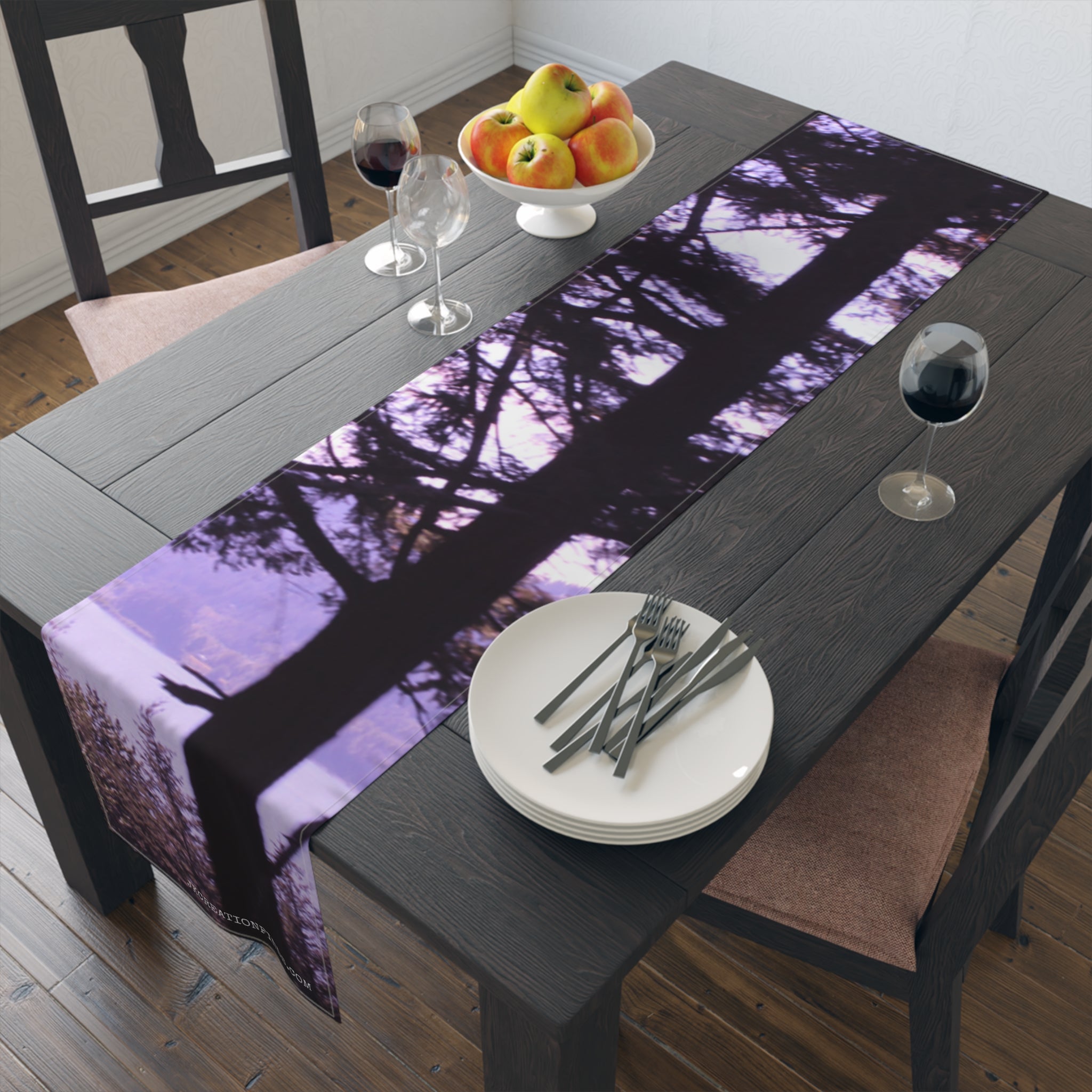 Table runner with purple tree silhouette and white plates with forks.