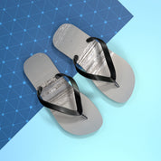 Pair of grey flip-flops with black straps on a blue gradient background.
