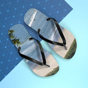 Flip-flops with a beach scene design on a blue patterned background.