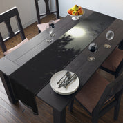 Dark wooden dining table with runner, place settings, and bowl of fruit.