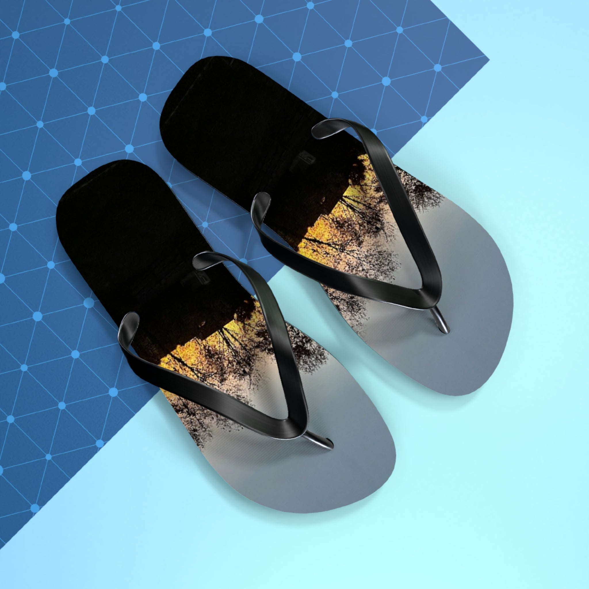 Flip-flops with a sunset tree silhouette design on black soles.