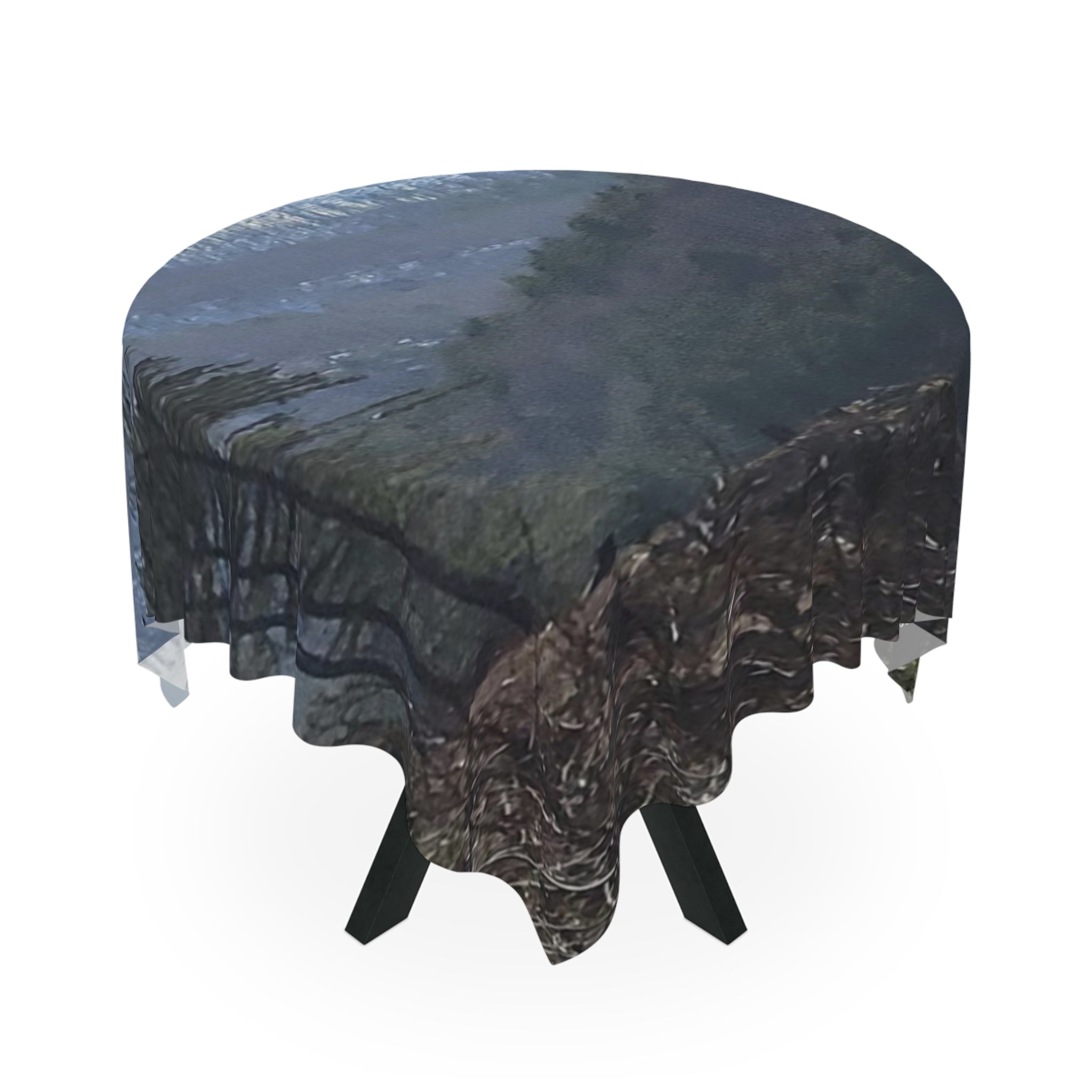 Tablecloth with a dark, textured pattern draped over a round table.