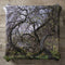 Gnarled branches of a tree with moss and new green leaves.