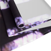 Rolled textile with a blurred purple and white floral pattern.
