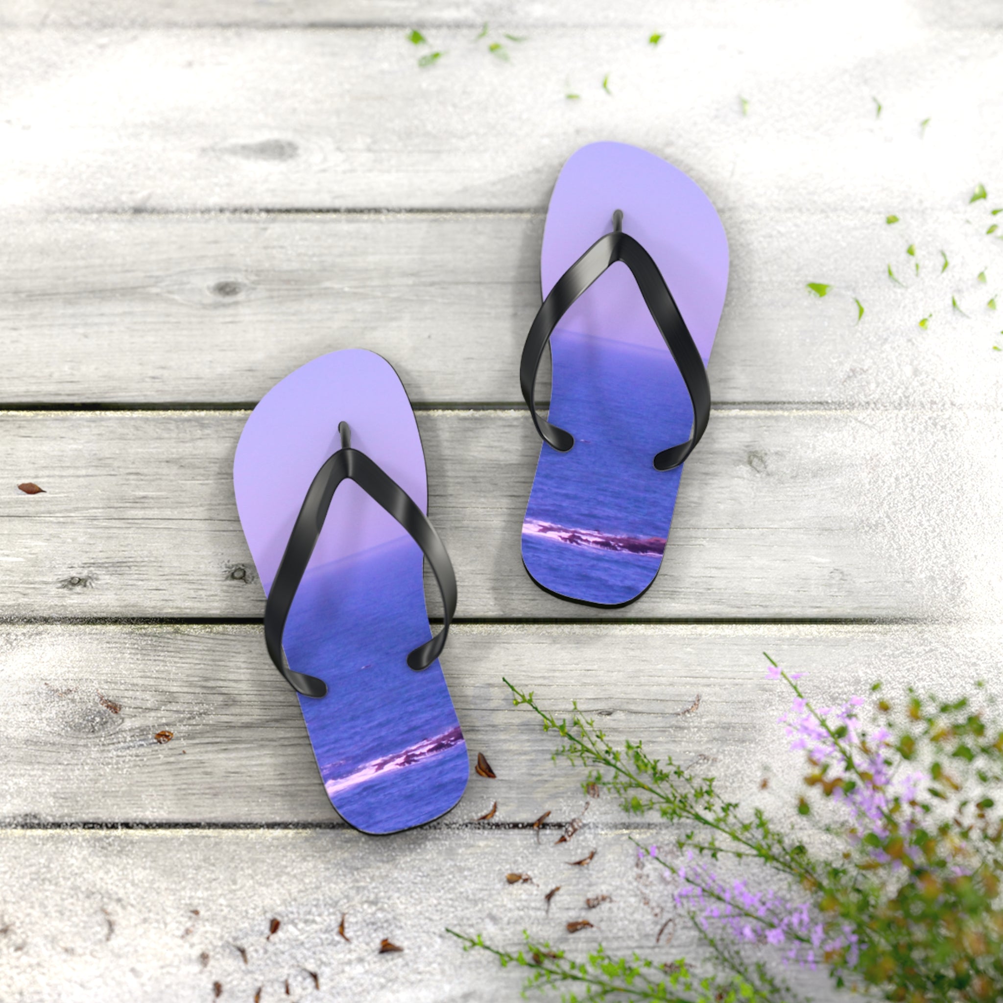 Purple flip-flops with an ocean scene on a weathered wooden surface.