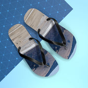Flip-flops with a landscape print on wooden planks and blue geometric background.