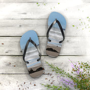 Flip-flops with a beach scene featuring two people on sand and rocks.