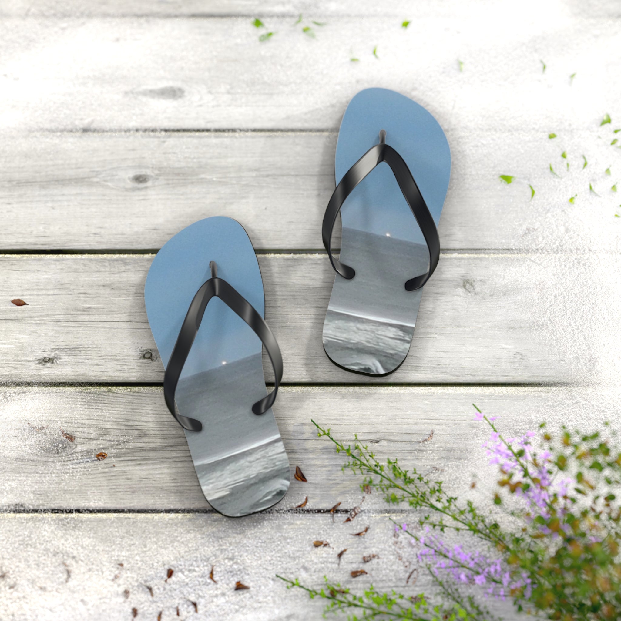 Blue flip-flops with a beach scene on the soles, resting on a wooden surface.
