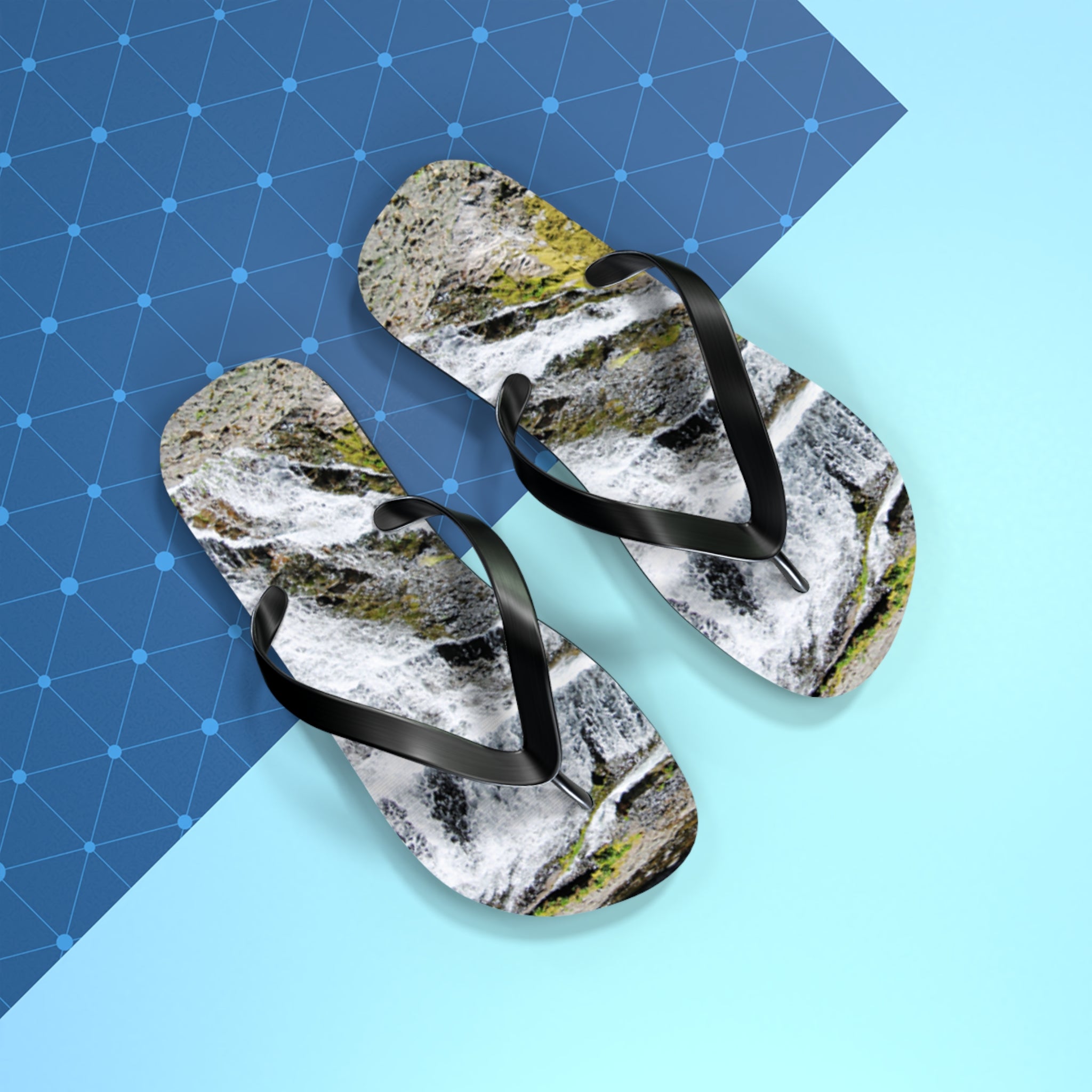 Flip-flops with waterfall print on a blue geometric background.