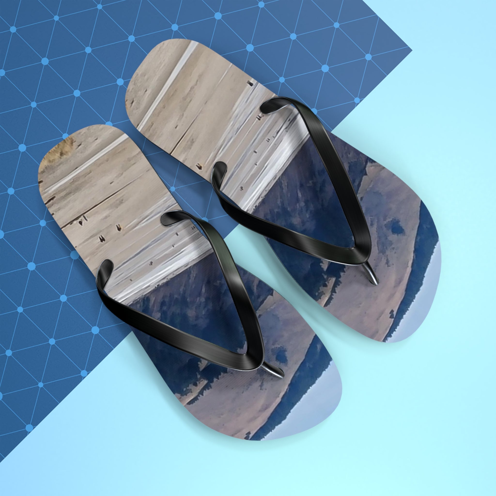 Flip-flops with a landscape print of a body of water and dry hills.
