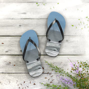 Blue flip-flops with a marble-like pattern on a wooden surface.