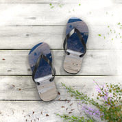 Flip-flops with a beach and mountain scene printed on soles, on wooden planks.