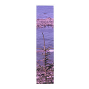Narrow banner showing a small evergreen tree in foreground and purple ocean.