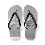 Flip-flops with a beach and ocean scene printed on the soles.