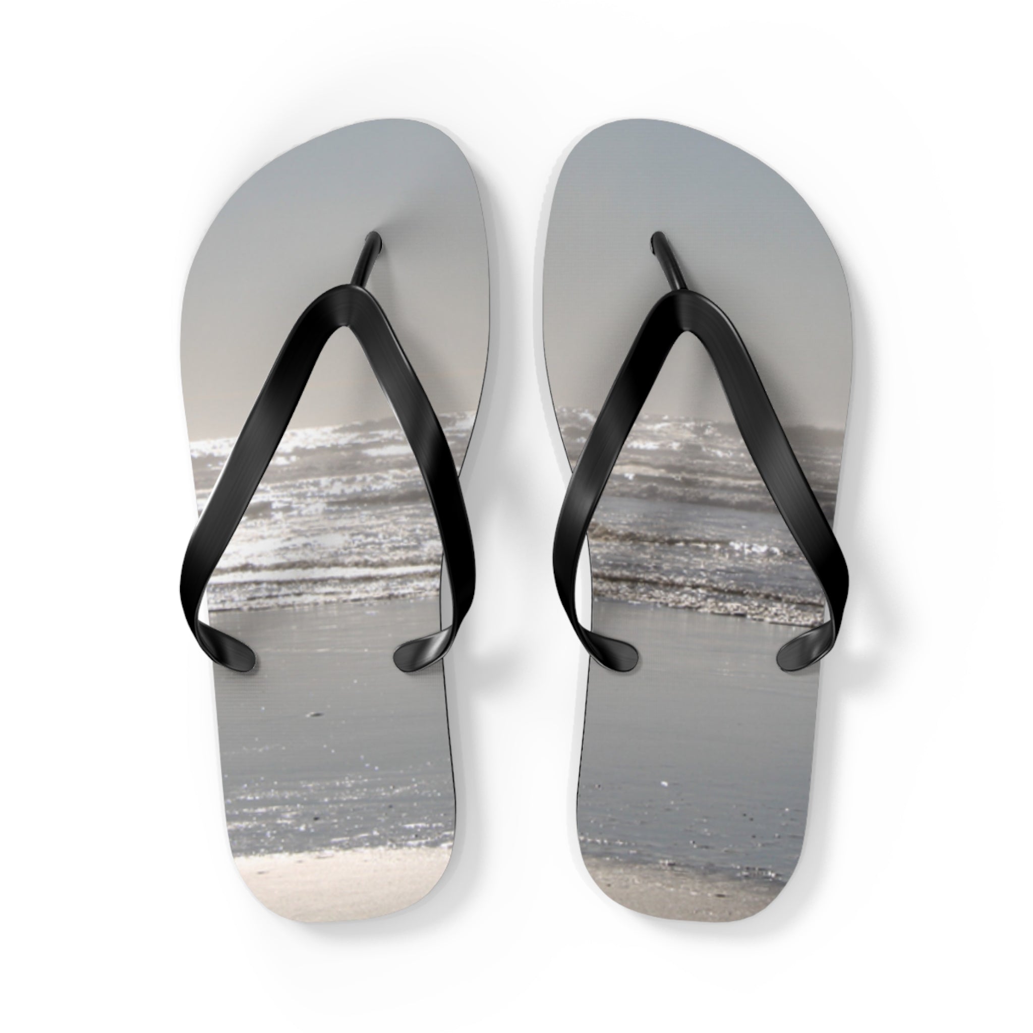 Flip-flops with a beach and ocean scene printed on the soles.