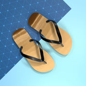 Golden brown flip-flops with black straps on a blue and light blue background.