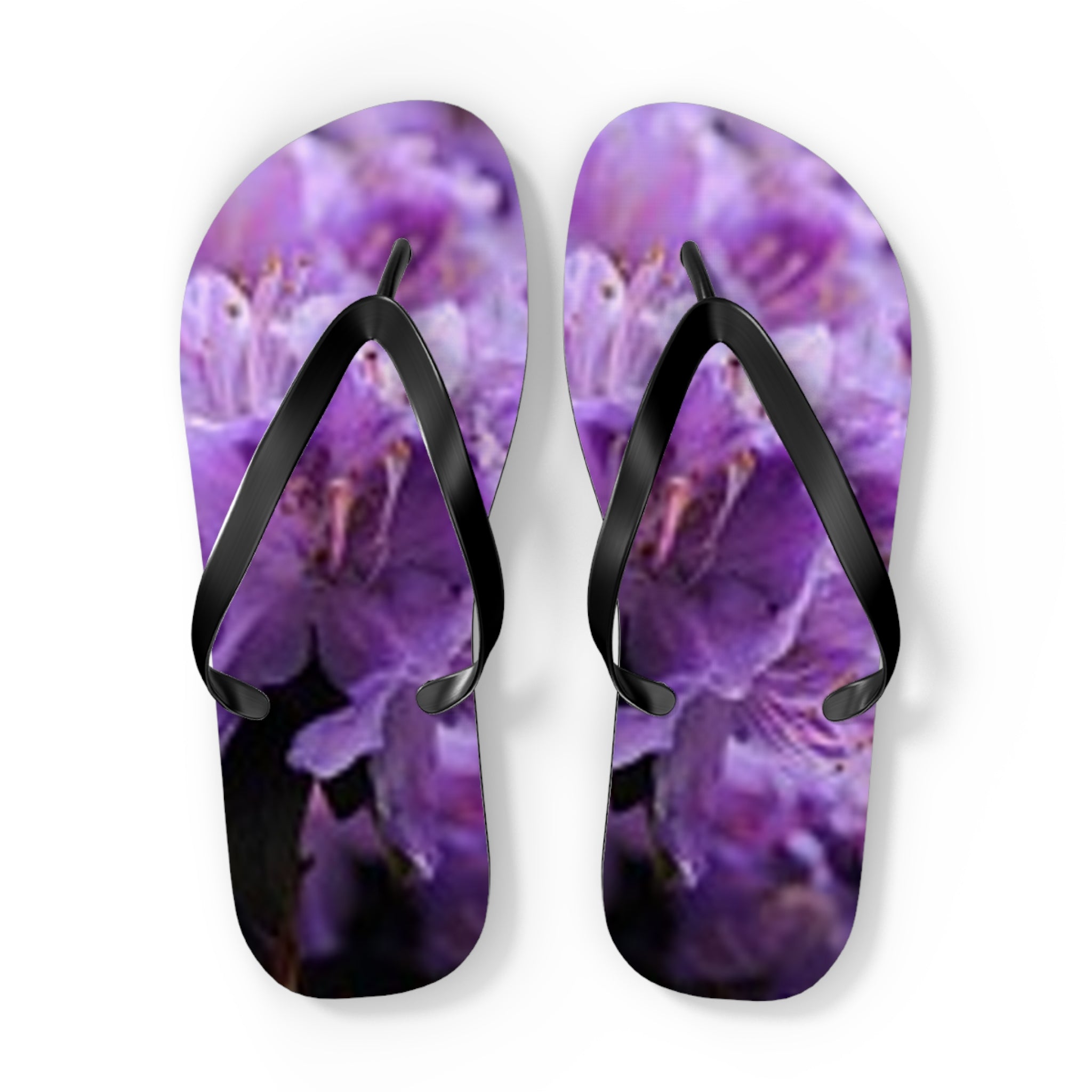 Purple floral flip-flops with black straps on a white background.