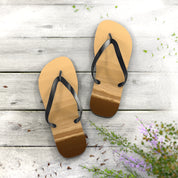 Flip-flops with beach scene inlay on weathered wooden planks.