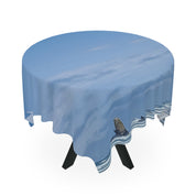 Round tablecloth with a sky and clouds pattern draped over a table.