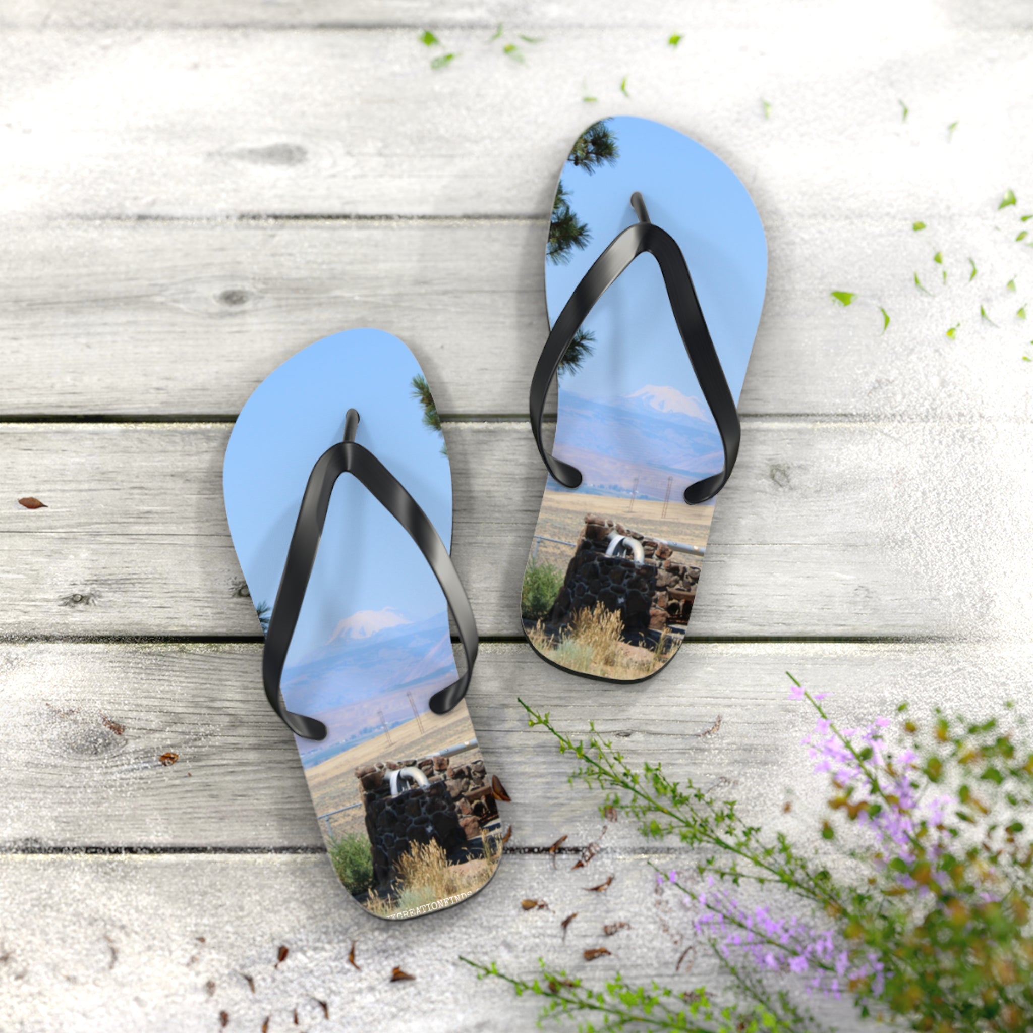 Flip flops featuring a scenic mountain view and rustic stone structure.