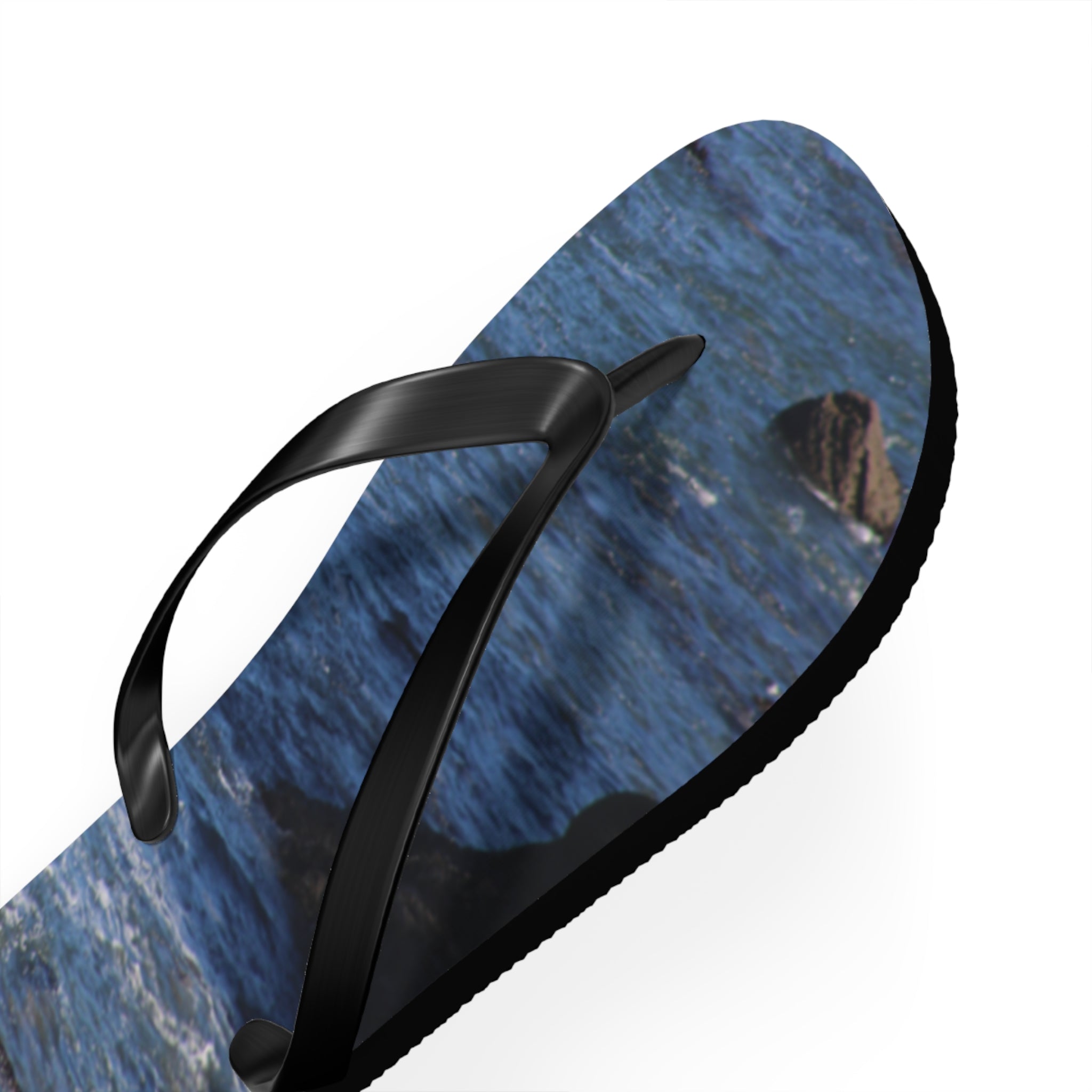 Black flip-flop with a close-up ocean wave pattern on the sole.