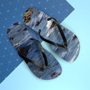 Flip flops with a crashing wave and rocky shore pattern on a blue grid.