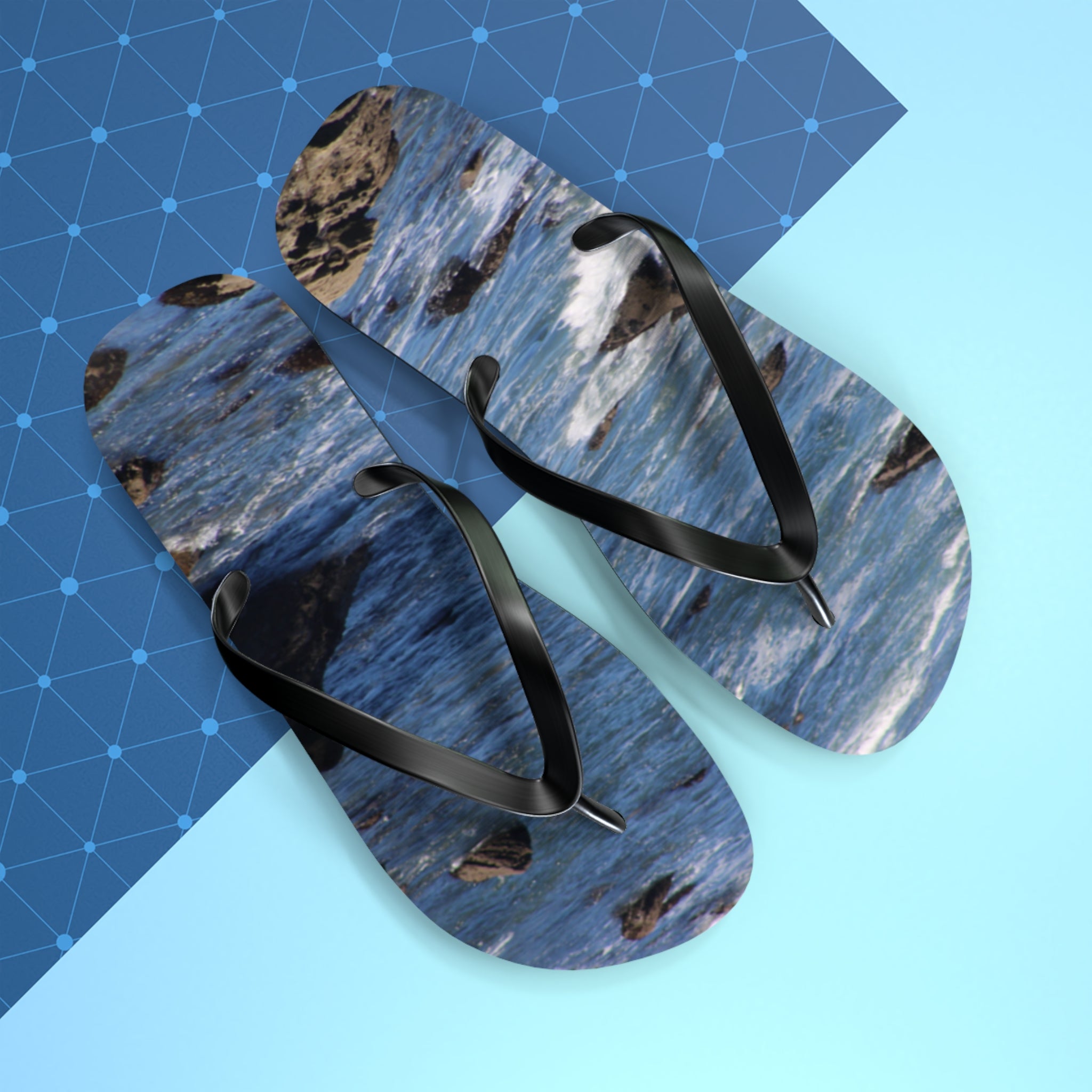 Flip flops with a crashing wave and rocky shore pattern on a blue grid.