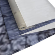 Rolled fabric swatch with marbled blue and gray pattern and white edge detail.