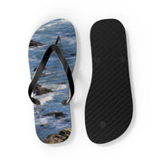 Flip-flops with wave and rock pattern on sole, white background.
